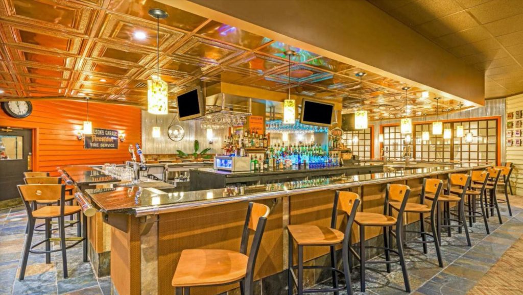 The bar at FenderZ Grill & Pub with copper ceiling and bar seating
